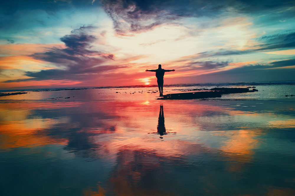 Person on beach enjoying sunset