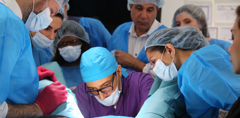 Dr Sherif Wakil performing intimate procedure with doctors around him