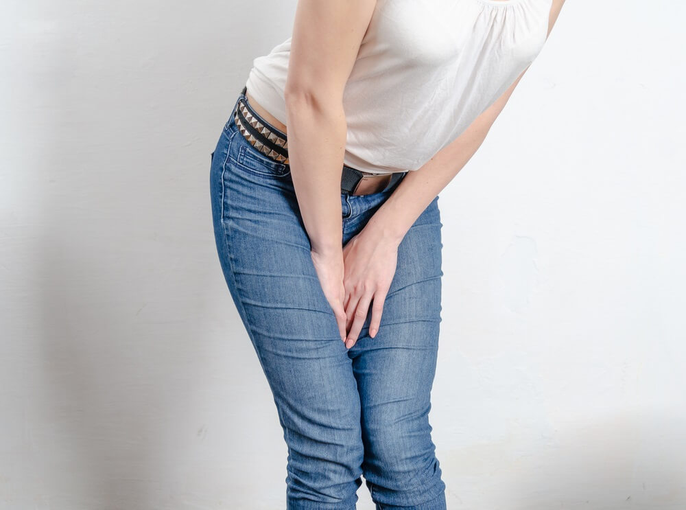 Woman bending over with hands between legs